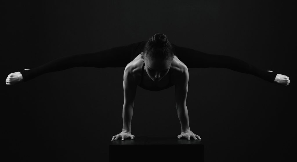 Jeune gymnaste planche écartée en noir et blanc low key
